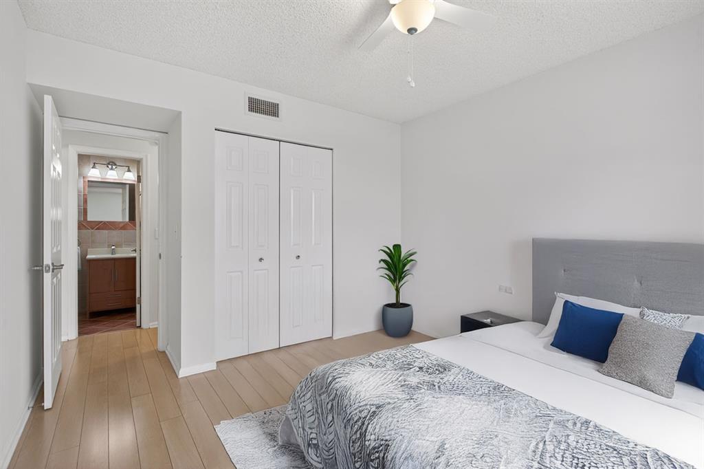 130 Cypress Club Drive, Unit 307 Pompano Beach, FL 33060 - Photo 8 of 35 a bed room with a bed and a chandelier