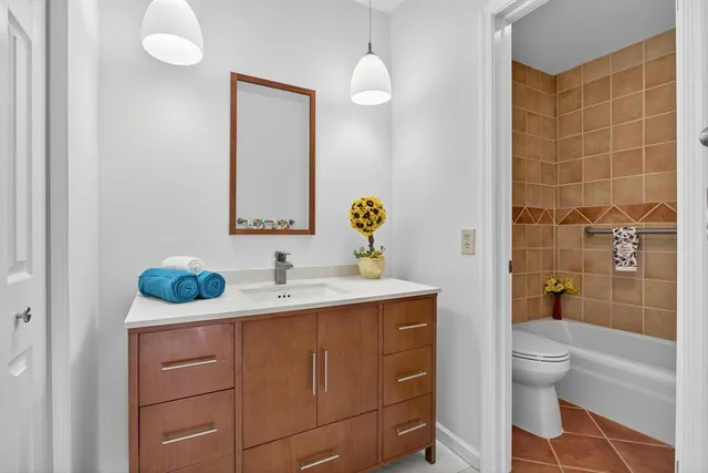 a bathroom with a granite countertop sink a toilet and a mirror