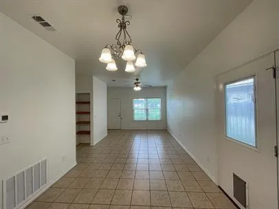a view of a livingroom with a chandelier fan and windows