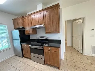 a kitchen with granite countertop a stove sink and cabinets