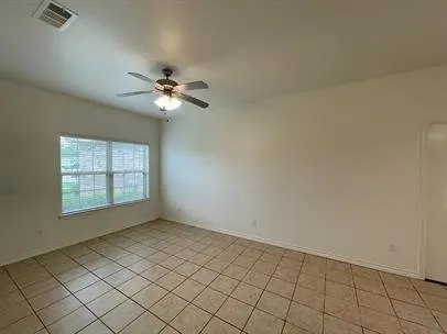 an empty room with windows and ceiling fan