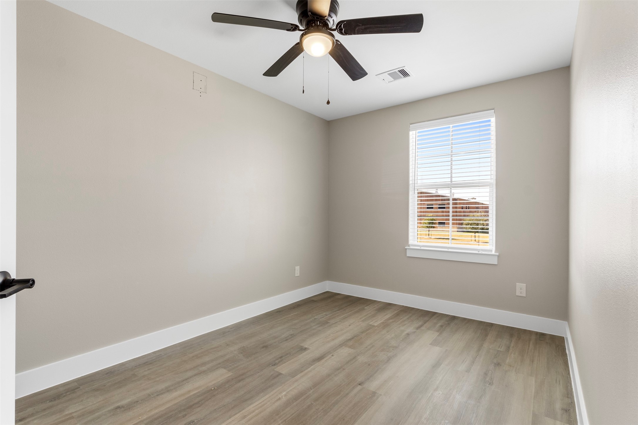 3152 South Cleveland Street Dayton, TX 77535 - Photo 10 of 22 wooden floor in an empty room with a window