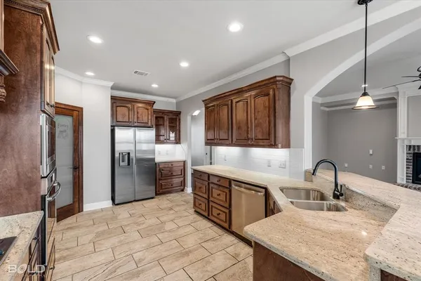 a kitchen with stainless steel appliances granite countertop a sink refrigerator and cabinets