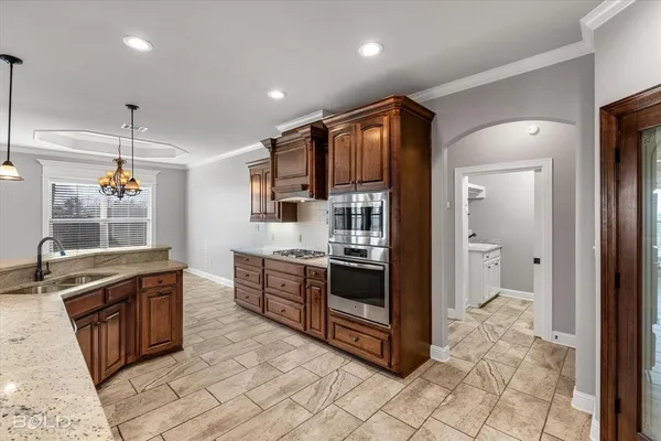 a kitchen with stainless steel appliances granite countertop a stove a sink and a refrigerator