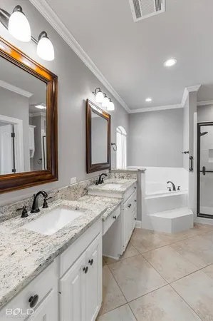 a bathroom with a granite countertop double vanity sink and mirror