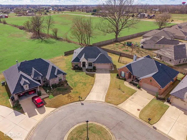 an aerial view of a house with garden space and a patio