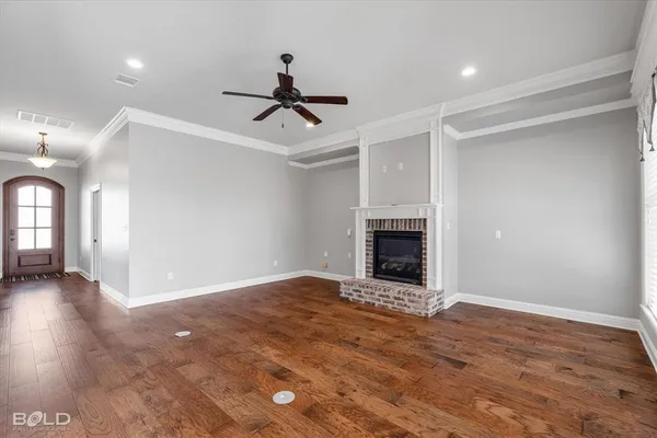 a view of an empty room with a fireplace and a window