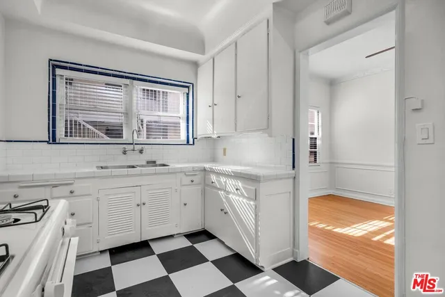 a kitchen with granite countertop white cabinets and appliances