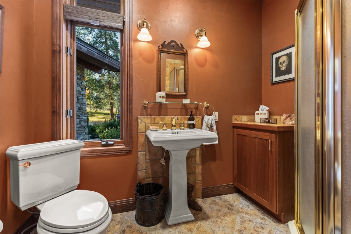 32350 Los Ranchos Road Oak Creek, CO 80467 - Photo 35 of 50 a bathroom with a sink mirror toilet and window