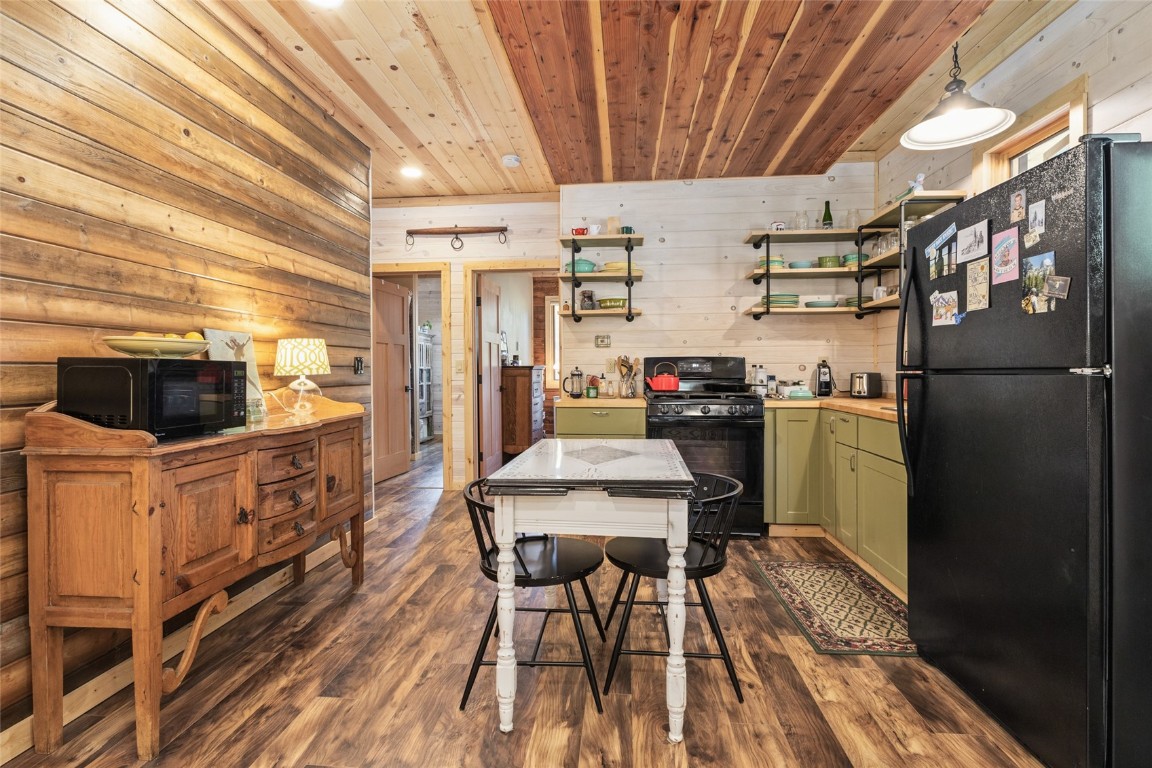 32350 Los Ranchos Road Oak Creek, CO 80467 - Photo 42 of 50 a kitchen with stainless steel appliances a refrigerator a stove a microwave oven a dining table and chairs with wooden floor