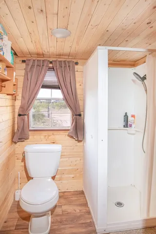 a bathroom with a toilet and a shower