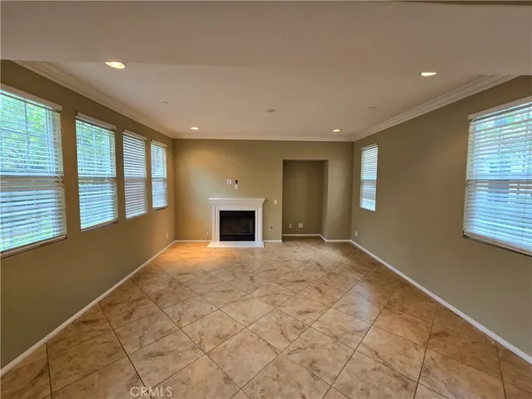 a view of an empty room with a fireplace and a window