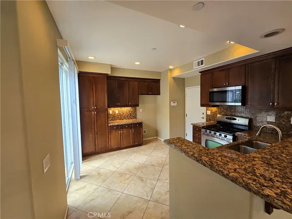 a kitchen with granite countertop a refrigerator and a sink