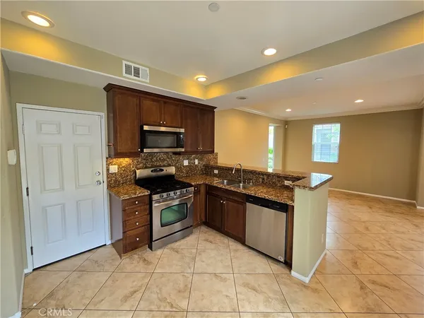 a kitchen with stainless steel appliances granite countertop a stove and a sink