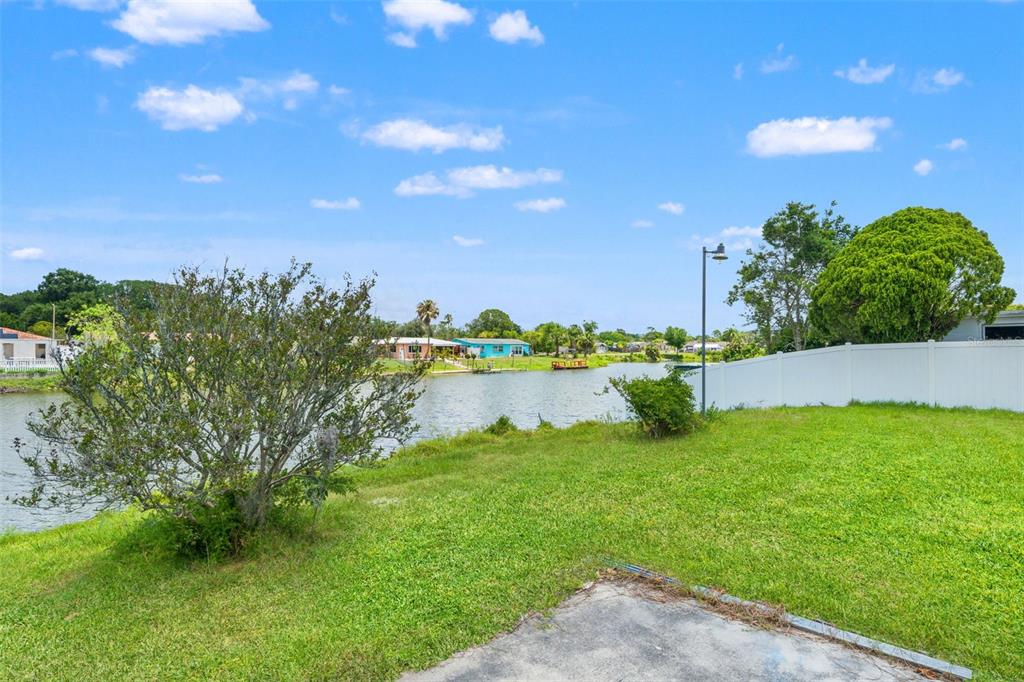 7211 Ashwood Drive Port Richey, FL 34668 - Photo 8 of 12 a view of a lake with a yard