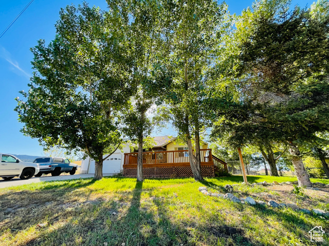 11473 South Dempsey Creek Road Lava Hot Springs, ID 83246 - Photo 1 of 47 View of front facade featuring a deck, a garage, a front yard, and an outdoor structure