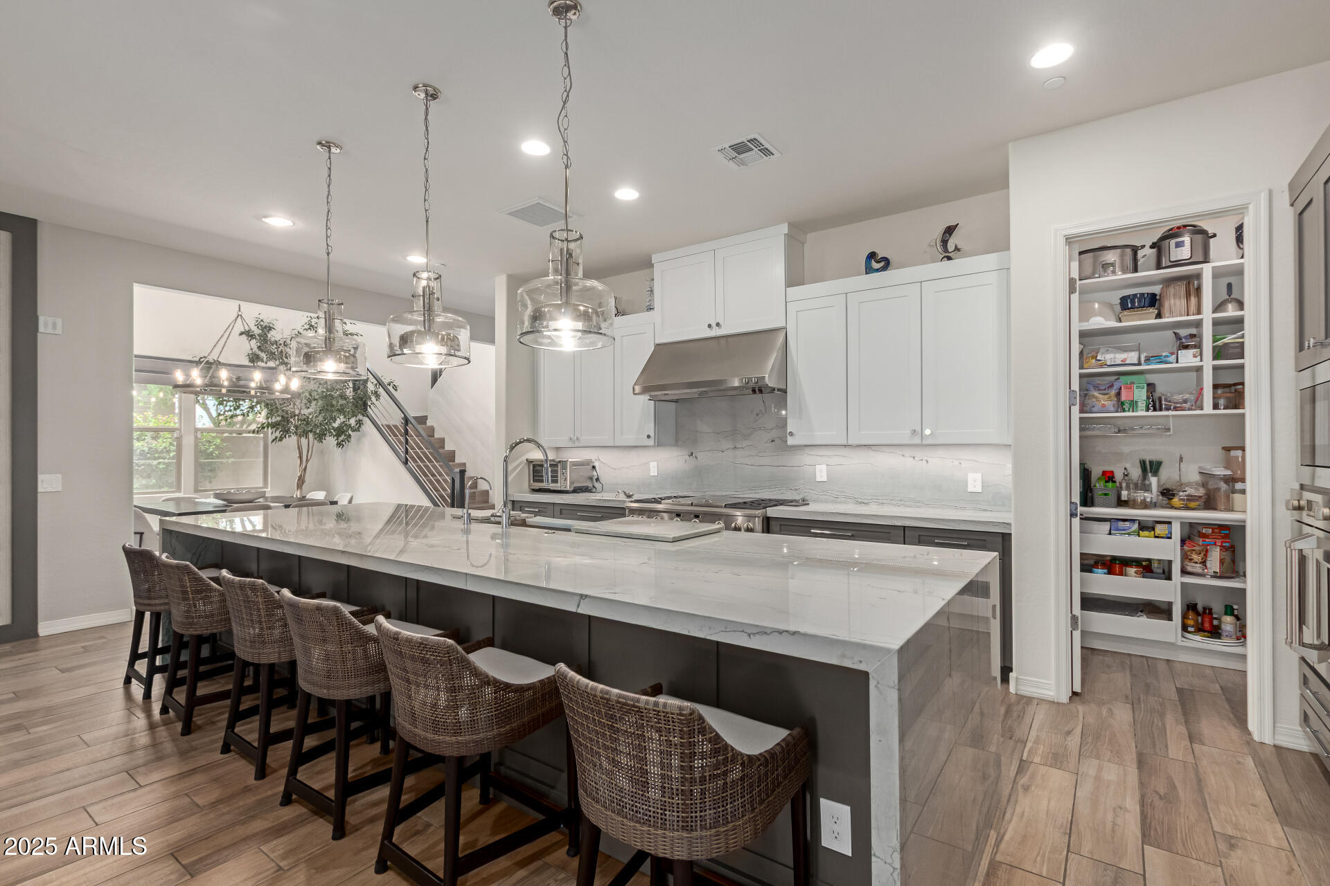 22943 North 73rd Way Scottsdale, AZ 85255 - Photo 1 of 49 a kitchen with kitchen island a dining table chairs and wooden floor