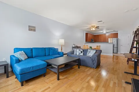 a living room with furniture and a dining table with kitchen view