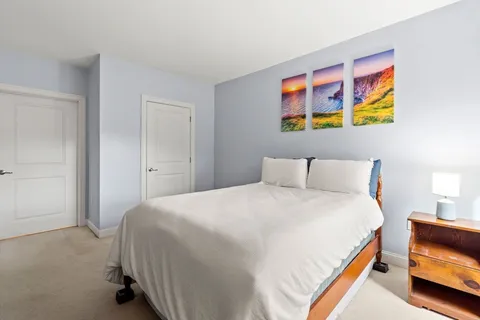 a bedroom with a bed and painting on the wall