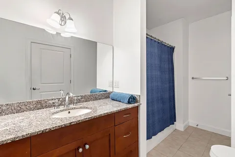 a bathroom with a granite countertop sink and a mirror