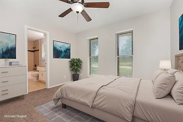 a bedroom with a large bed and ceiling fan