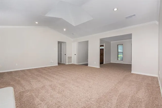 a view of an empty room with closet and a window
