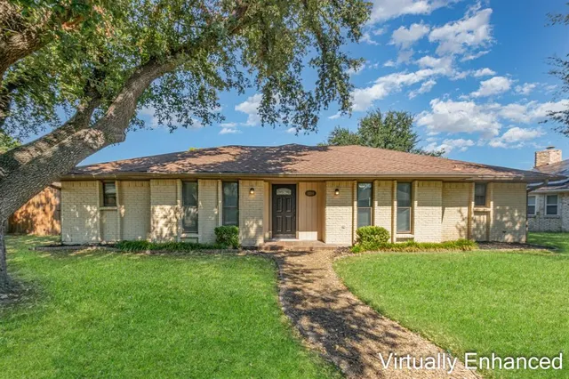 a front view of a house with a garden and trees