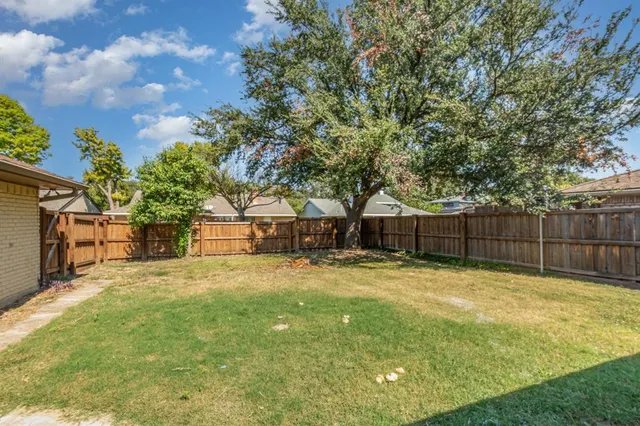 a backyard of a house with table and chairs