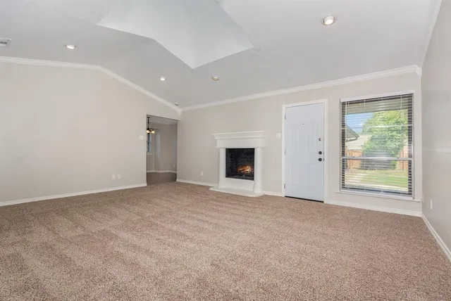 an empty room with windows and fireplace