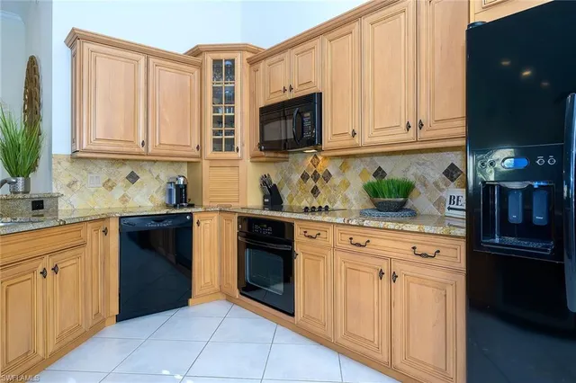 a kitchen with stainless steel appliances granite countertop a refrigerator and a stove top oven