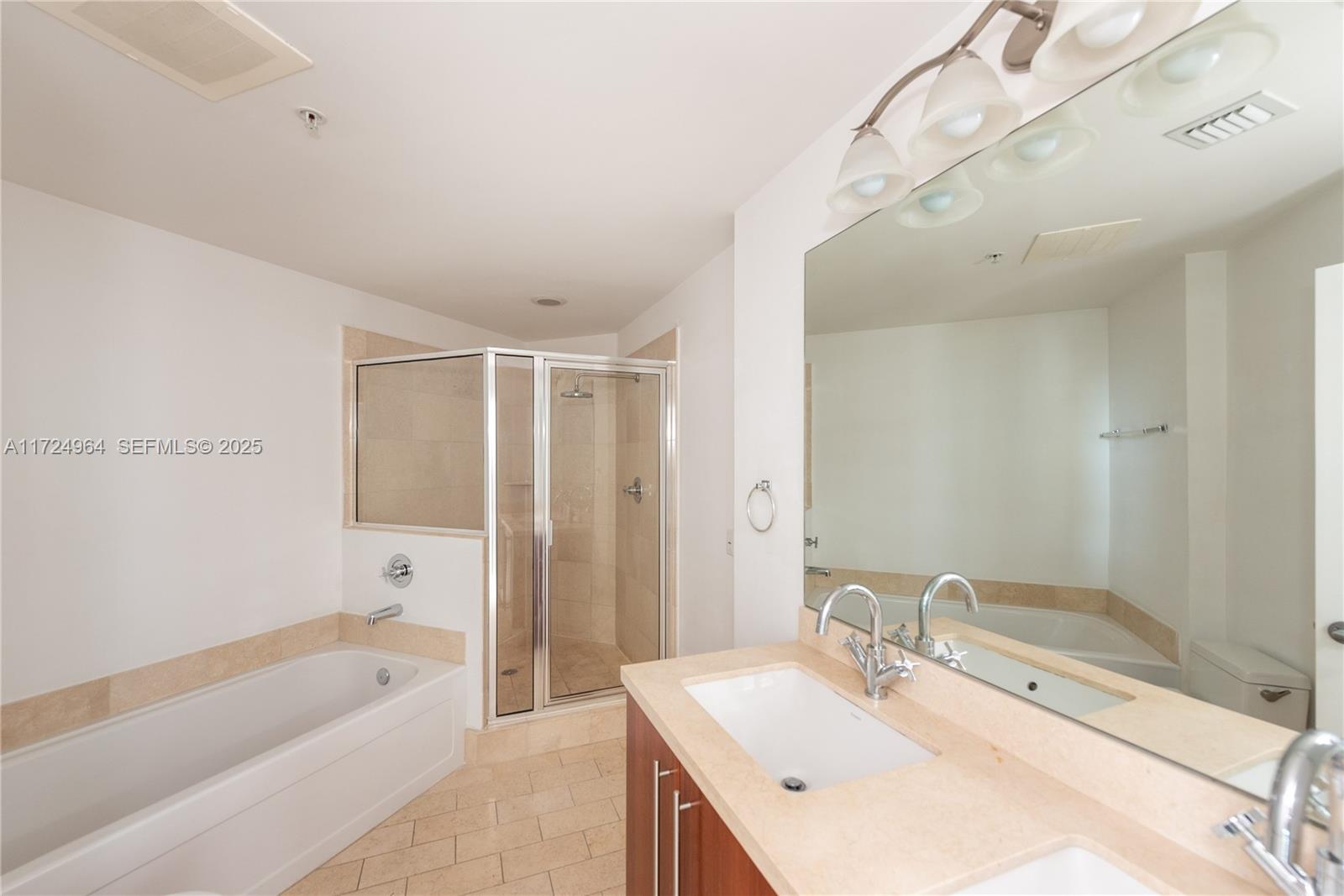 79 Southwest 12th Street, Unit 1107S Miami, FL 33130 - Photo 13 of 26 a bathroom with a tub sink and mirror