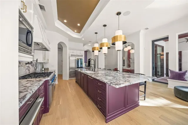 a kitchen with stainless steel appliances granite countertop a sink stove and cabinets