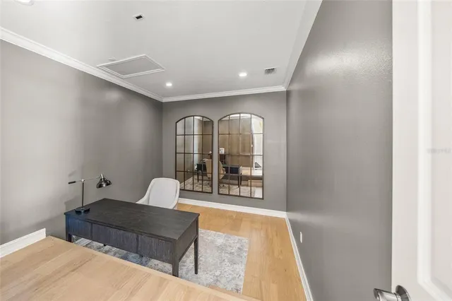 a front view of a house with garden and a tree