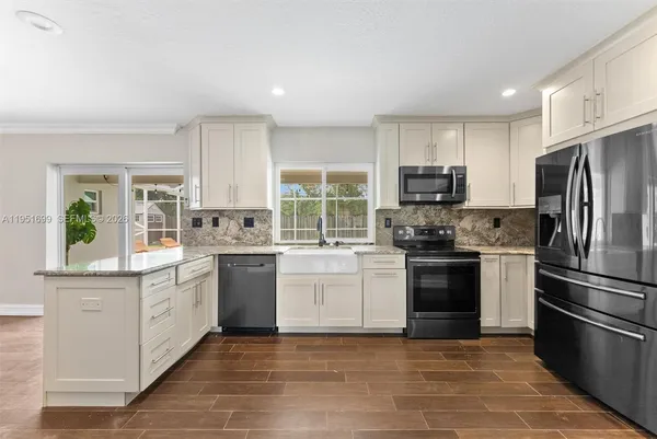 a kitchen with stainless steel appliances granite countertop a stove a sink and a refrigerator