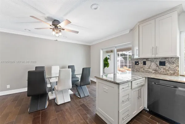 a kitchen with stainless steel appliances white cabinets and wooden floor