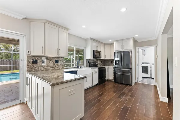 a kitchen with stainless steel appliances granite countertop a refrigerator and a stove top oven