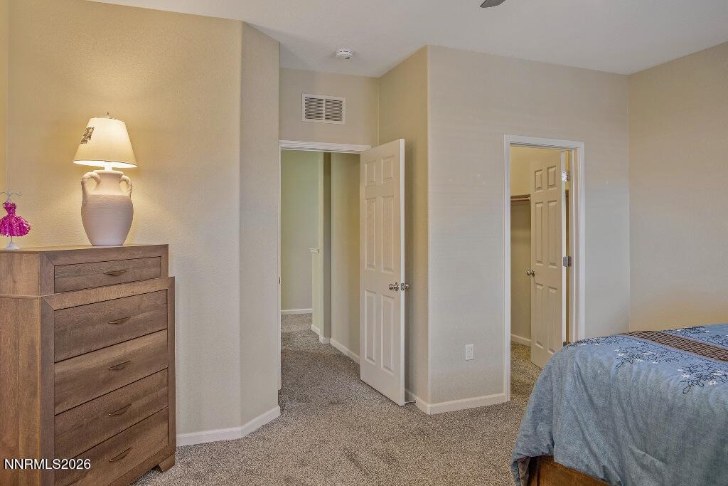1864 Wind Ranch Road, Unit B Reno, NV 89521 - Photo 19 of 42 a bedroom with a bed and a mirror