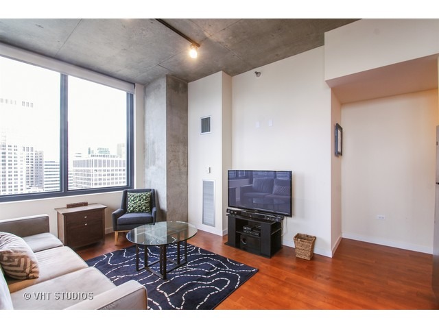 235 West Van Buren Street, Unit 3315 Chicago, IL 60607 - Photo 2 of 23 a living room with furniture and a flat screen tv