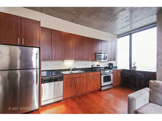 235 West Van Buren Street, Unit 3315 Chicago, IL 60607 - Photo 3 of 23 a kitchen with stainless steel appliances granite countertop a refrigerator stove top oven and sink
