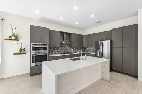 a kitchen with stainless steel appliances granite countertop a refrigerator sink and stove