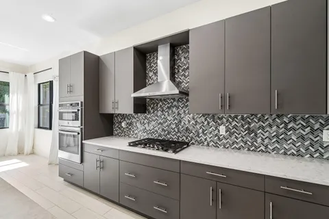 a kitchen with stainless steel appliances granite countertop a sink and a refrigerator