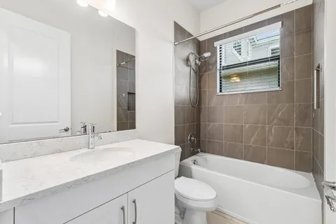 a bathroom with a sink a toilet a mirror a bathtub and shower