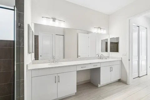 a bathroom with a granite countertop sink double and mirror
