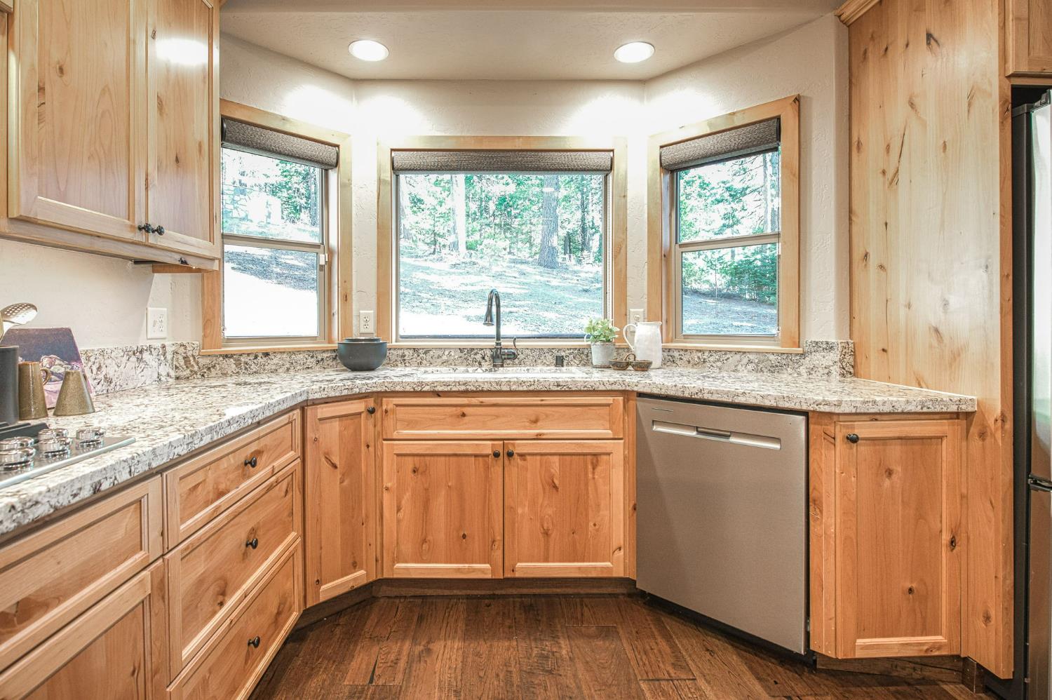 41876 Timber View Lane Shaver Lake, CA 93664 - Photo 40 of 85 a kitchen with granite countertop wooden cabinets stainless steel appliances a sink and a window
