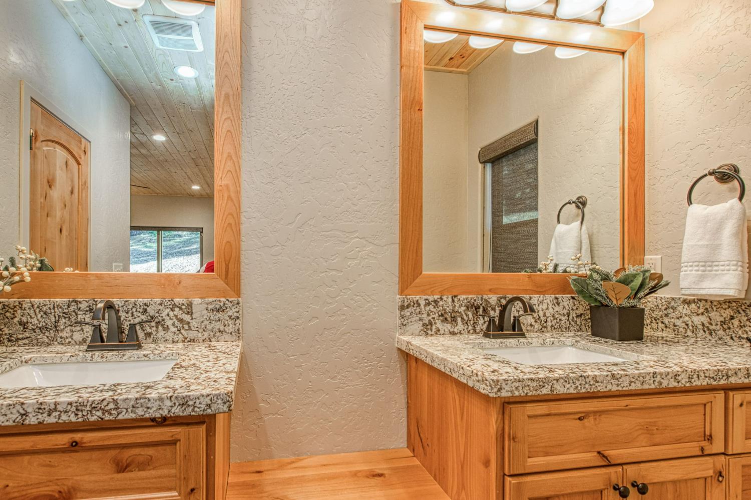 41876 Timber View Lane Shaver Lake, CA 93664 - Photo 52 of 85 a bathroom with a granite countertop sink and a mirror