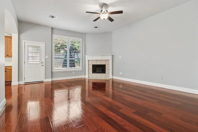 wooden floor fireplace and windows in an empty room