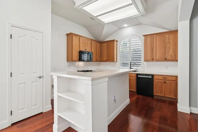a kitchen with stainless steel appliances white cabinets and wooden floor