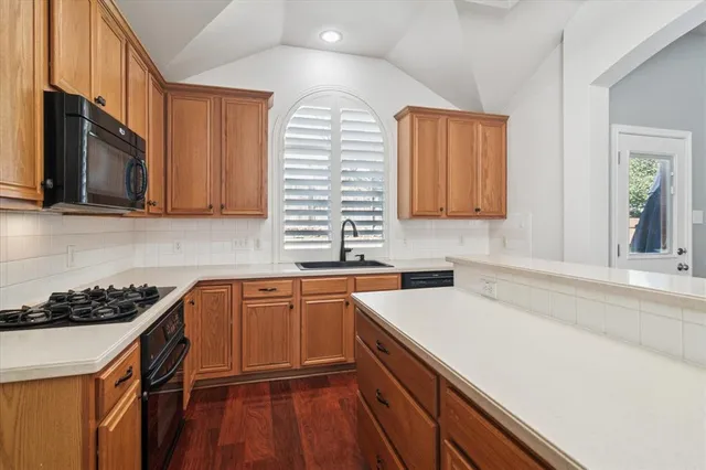 a kitchen with stainless steel appliances granite countertop a sink stove and microwave