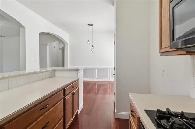 a kitchen with stainless steel appliances granite countertop a stove a sink and a microwave