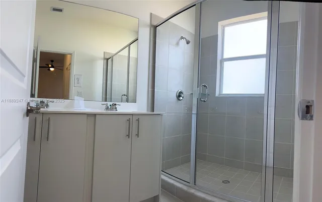 a bathroom with a shower sink and mirror